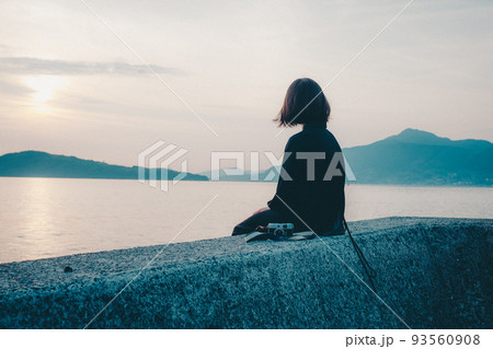 女性と美しい夕焼け空 93560908