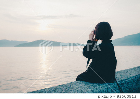 女性と美しい夕焼け空 93560913