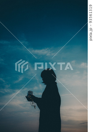 女性のシルエットと美しい夕焼け空 女性のシルエットと美しい夕焼け空 93561319