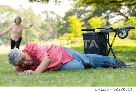 Asian senior man falling down from wheelchair on lying floor after trying push the wheelchair forward and Crying in pain and asking someone for help. Concept of old elderly insurance and health care 93570614