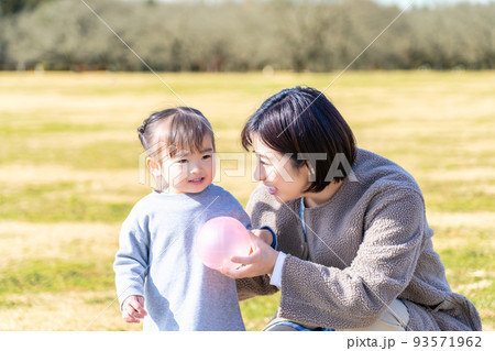 公園の芝生広場で遊ぶ園児と保育士 公園の芝生広場で遊ぶ園児と保育士 93571962