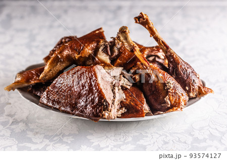 Portioned roast goose on a white plate - Close up 93574127