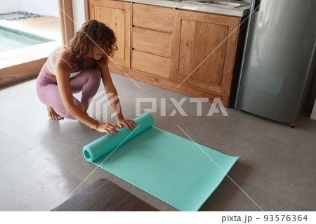 Exercise At Home. Woman Rolling Yoga Mat After Practicing 93576364