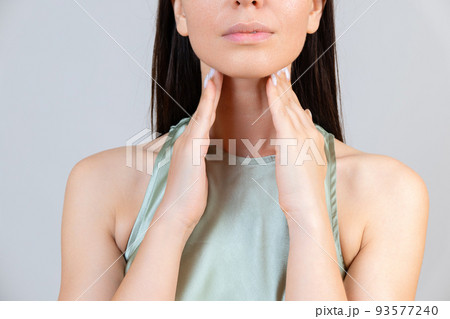 Sore throat in flu season. Young asian woman touching her neck and feeling pain in throat in the bedroom at home. Sore throat in flu season. Young asian woman touching her neck and feeling pain in throat in the bedroom at home. 93577240