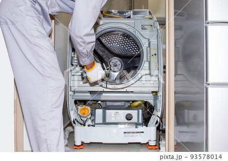 分解された洗濯機と電動工具を持つ業者 93578014