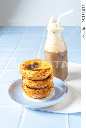 Portuguese dessert Pastel de nata with creamy coffee on blue tile 93581036