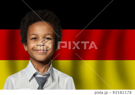German kid boy on flag of Germany background. Education and childhood concept 93582178