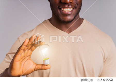 latin brazilian man holding a lightbulb in hands concept of idea and creativity 93583558