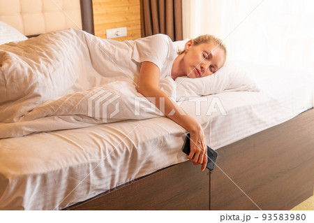 Woman beautiful phone mobile sleep blonde bed blanket view lying, for adult pillow in dream and smile rest, bedtime light. Indoors breathing relaxing, Woman beautiful phone mobile sleep blonde bed blanket view lying, for adult pillow in dream and smile rest, bedtime light. Indoors breathing relaxing, 93583980