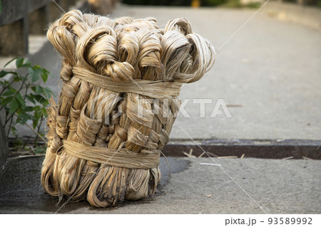 A thick brown  bundle of  raw jute has on the ground     93589992