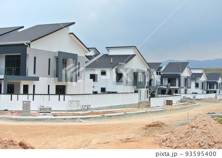 SELANGOR, MALAYSIA - JUNE 18, 2022: New double-story terrace house under construction in Malaysia. This house has a wide front porch and is fenced. Has basic facilities. SELANGOR, MALAYSIA - JUNE 18, 2022: New double-story terrace house under construction in Malaysia. This house has a wide front porch and is fenced. Has basic facilities. 93595400
