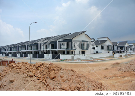 SELANGOR, MALAYSIA - JUNE 18, 2022: New double-story terrace house under construction in Malaysia. This house has a wide front porch and is fenced. Has basic facilities. 93595402