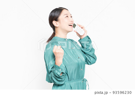 電話の子機を使っている主婦 93596230