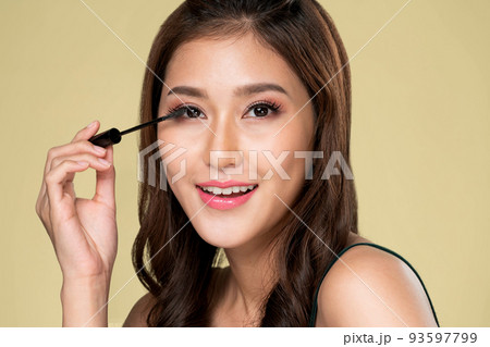 Ardent young woman putting black mascara on her long eyelashes with brush. Ardent young woman putting black mascara on her long eyelashes with brush. 93597799