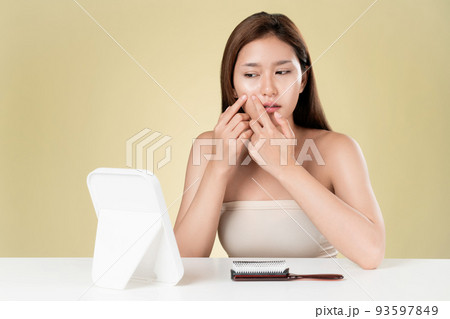 Portrait of ardent asian woman looking at mirror worry about pimple. 93597849
