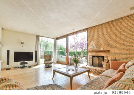 Interior of modern room illuminated with sunlight from ceiling window and door in modern house Interior of modern room illuminated with sunlight from ceiling window and door in modern house 93599946