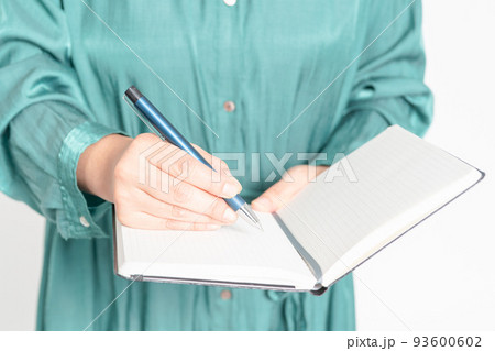 ノートにメモを書く女性の手元 93600602