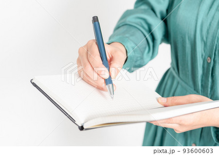 ノートにメモを書く女性の手元 93600603