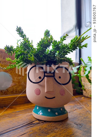 Beautiful ceramic planter with homemade flowers on the table. 93600767