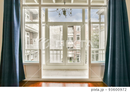 Front view of old brick buildings from small balcony with railings 93600972