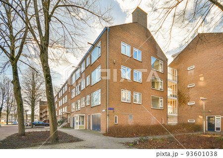 Panorama view of brick houses from an empty sidewalk street with trees and lanterns Panorama view of brick houses from an empty sidewalk street with trees and lanterns 93601038