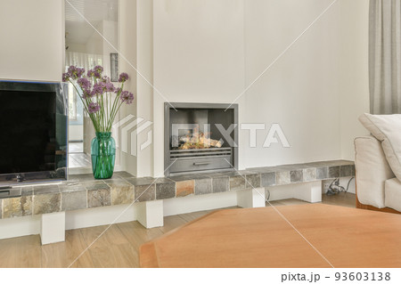 Shabby wooden table with chairs and vase located near comfortable couch against light walls with decorations and TV in modern apartment Shabby wooden table with chairs and vase located near comfortable couch against light walls with decorations and TV in modern apartment 93603138