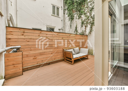 Neat paved patio with sitting area near wooden fence Neat paved patio with sitting area near wooden fence 93603188