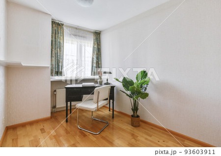 Comfortable chair placed near table with against blank whiteboard and mirror in light home office in contemporary flat 93603911