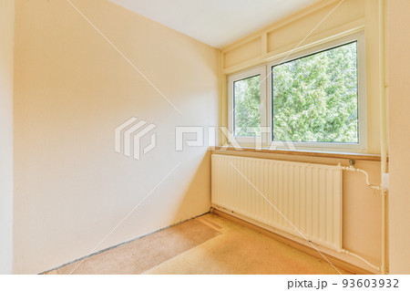 Plastic window and radiator on white wall in empty light room at home 93603932