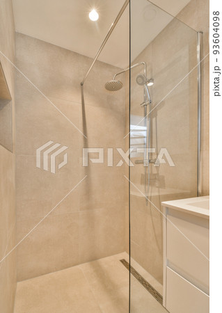 Sinks with mirrors and shower box with glass door in modern bathroom with white tiled walls 93604098
