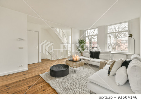 Shabby wooden table with chairs and vase located near comfortable couch against light walls with decorations and TV in modern apartment Shabby wooden table with chairs and vase located near comfortable couch against light walls with decorations and TV in modern apartment 93604146