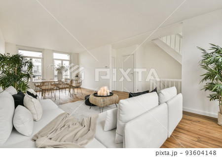 Shabby wooden table with chairs and vase located near comfortable couch against light walls with decorations and TV in modern apartment Shabby wooden table with chairs and vase located near comfortable couch against light walls with decorations and TV in modern apartment 93604148