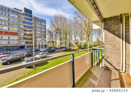 Narrow brick balcony with metal railings and door 93604224