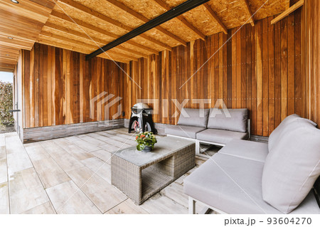 Neat paved patio with sitting area and small garden near wooden fence 93604270