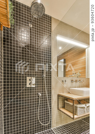 Sinks with mirrors and shower box with glass door in modern bathroom with white tiled walls 93604720