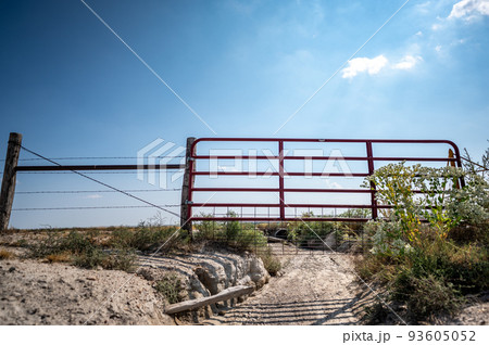 Water gap under a livestock fence where animals can go under a washed out section Water gap under a livestock fence where animals can go under a washed out section 93605052
