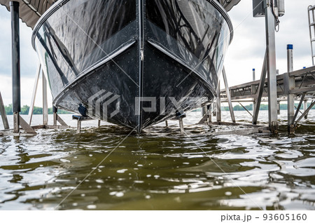 Boat with a hydraulic dock lift sitting above the water line on a lake. 93605160