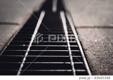 Grate over a stormwater trench in a concrete slab. Grate over a stormwater trench in a concrete slab. 93605398