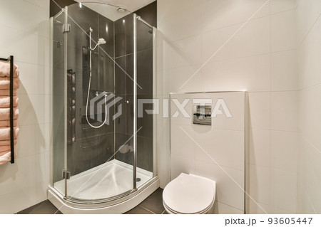 Black wall hung toilet in minimalist interior of bathroom with shower cabin 93605447