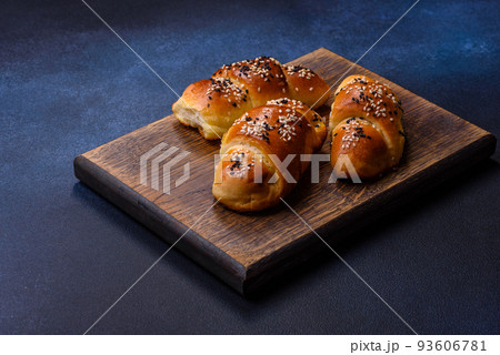 Delicious homemade pastries with apricot jam sprinkled with sesame seeds Delicious homemade pastries with apricot jam sprinkled with sesame seeds 93606781