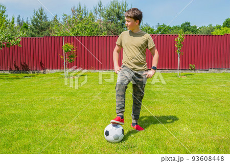 A boy with a ball in the backyard on a sunny summer day. Sport games. Healthy lifestyle concept. 93608448