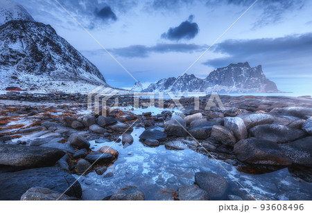 Sea coast with stones and blurred water, snowy rocky mountains 93608496
