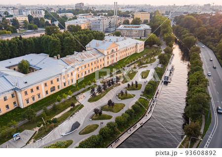 Aerial view of the public park of the Karpovka River Embankment in St. Petersburg at sunset, Russia, recreation areas, benches and amphitheater, botanical garden opposite the park Aerial view of the public park of the Karpovka River Embankment in St. Petersburg at sunset, Russia, recreation areas, benches and amphitheater, botanical garden opposite the park 93608892