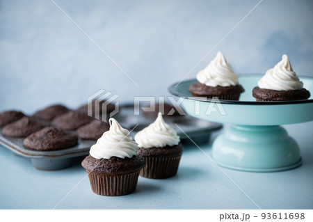 chocolate cupcake with white icing on blue background 93611698