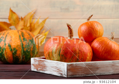 Autumn harvest. Ripe pumpkins in wooden box. Thanksgiving and halloween concept. Eco-friendly farm products. Autumn harvest. Ripe pumpkins in wooden box. Thanksgiving and halloween concept. Eco-friendly farm products. 93612104