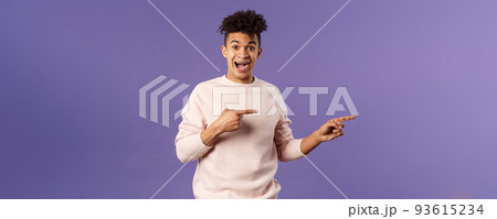 Portrait of enthusiastic lively hipster male 25s, pointing fingers right inviting join courses, sign up for awesome deal, best delivery service or online shop, look amused and happy camera 93615234