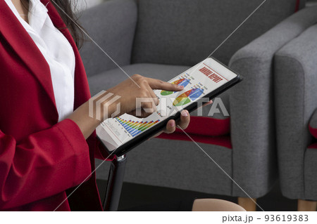 Bussineswoman working on annual report showing on electronic tablet. Bussineswoman working on annual report showing on electronic tablet. 93619383