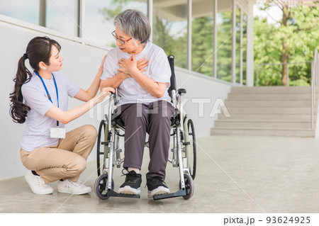 介護士と胸をおさえる高齢者 93624925