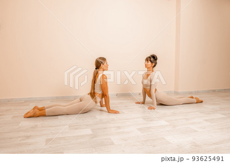 Well looking middle aged womans, fitness instructor in beige sportswear, preparing for stretching and pilates on yoga mat in the gym. Female fitness yoga concept. Healthy lifestyle harmony, meditation Well looking middle aged womans, fitness instructor in beige sportswear, preparing for stretching and pilates on yoga mat in the gym. Female fitness yoga concept. Healthy lifestyle harmony, meditation 93625491
