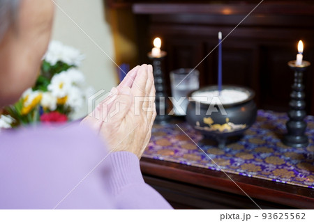 仏壇に手を合わせるお年寄り 93625562